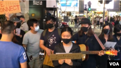 香港反送中示威者在重庆大厦门前演唱“ 愿荣光归香港”等粤语歌曲。