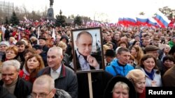 2018年3月14日,克里米亚黑海港口塞瓦斯托波尔举行俄罗斯吞并乌克兰克里米亚地区四周年纪念大会,有人举着普京肖像。
