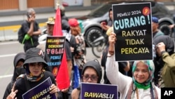 Para pengunjuk rasa membawa poster bertuliskan slogan-slogan dalam demo di luar kantor Badan Pengawas Pemilihan Umum (Bawaslu) untuk memprotes dugaan kecurangan pemilu pada pilpres 14 Februari lalu di Jakarta, Senin, 19 Februari 2024. (Foto: Achmad Ibrahim/AP Photo)