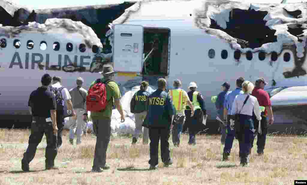 Nhân viên điều tra của Ủy Ban An toàn Giao thông Quốc gia Mỹ (NTSB) làm việc tại hiện trường tai nạn tại Sân bay Quốc tế San Francisco ở San Francisco, California, ngày 7/7/2013.