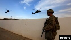 资料照片:美军在伊拉克摩苏尔袭击伊斯兰国武装分子的行动中,一名美国陆军士兵手持武器站在摩苏尔附近地区的军事基地。2016年10月18日拍摄。 (路透社照片)