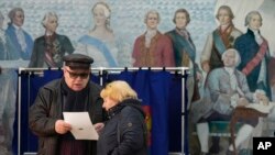 2024年3月16日,星期六,俄罗斯圣彼得堡举行总统选举,人们在一所学校的投票站检查选票。