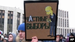 12月24日在大示威中手举漫画的抗议者,漫画上面写道:普京把诚实选举变成个人选举