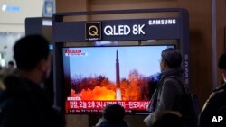 在韩国首尔的一个火车站内,人们正在观看电视屏幕上报道朝鲜试射导弹的消息。(2022年1月14号)