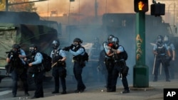 明尼阿波利斯市的警察监视因弗洛伊德之死引发的抗议活动(五月二十九号 路透社照片)。