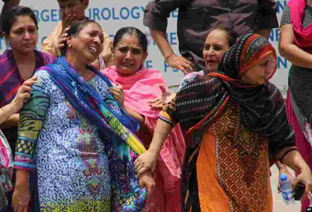 Women mourn as they visit a local hospital following an attack on a bus in Karachi, May 13, 2015.
